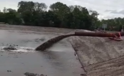 Zand wordt opgespoten in het zanddepot van de Zeeheldenwijk via een persleiding