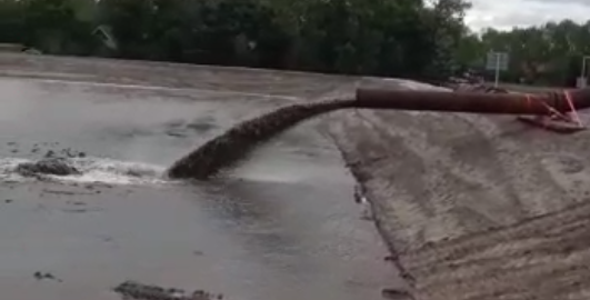 Zand wordt opgespoten in het zanddepot van de Zeeheldenwijk via een persleiding